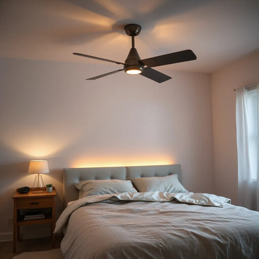 Modern ceiling fan above a quiet bedroom with warm lamp light and neutral bedding