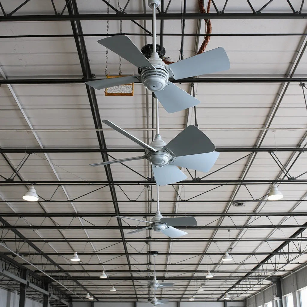 Industrial ceiling fans installed on a high warehouse ceiling with bright lighting