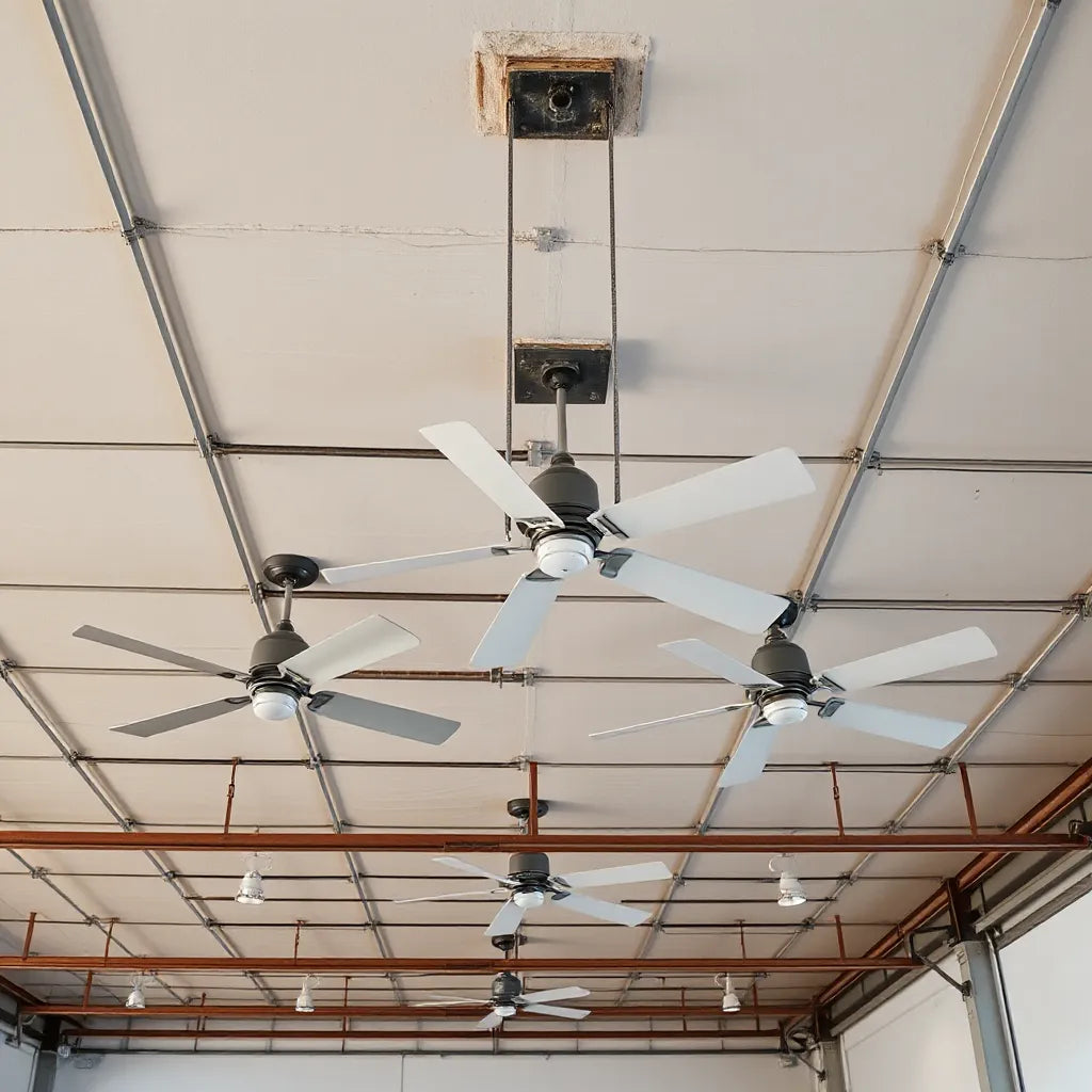 Industrial ceiling fans mounted on a high warehouse ceiling with visible blades and mounting hardware